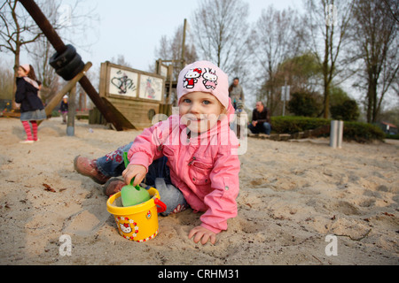 Mädchen mit Sand formt auf Kinderspielplatz Stockfoto