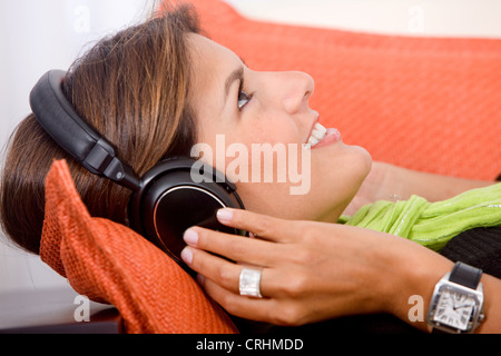 junge nette Frau entspannen, hören von Musik mit Kopfhörern, Lächeln Stockfoto