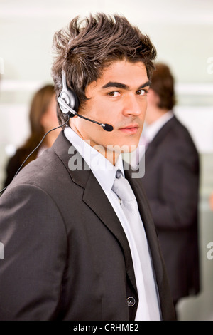 junger Mann mit Kopfhörer in einem Büro Stockfoto