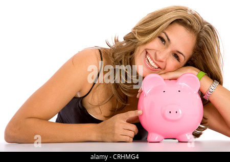 schöne junge Frau liegend den Kopf auf ein rosa Sparschwein glücklich lächelnd Stockfoto