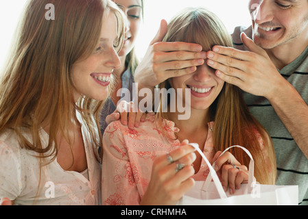 Freunde, die gerade junge Frau Eröffnung Geschenk Stockfoto
