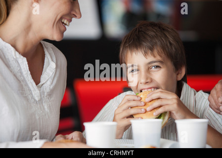 Junge Hamburger Essen in Fast-Food-restaurant Stockfoto