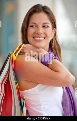 junge hübsche Frau mit bunten Einkaufstüten Stockfoto