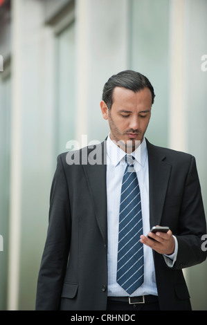 Business executive Text messaging mit Handy Stockfoto
