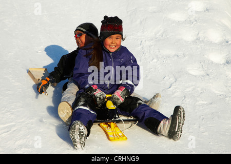 Kinder spielen im Schnee, Grönland, Ostgroenland, Tunu, Kalaallit Nunaat, Scoresbysund, Kangertittivag, Ittoqqortoormiit Stockfoto