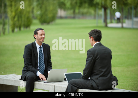 Unternehmensleiter diskutieren arbeiten bei der Nutzung von Laptops im freien Stockfoto