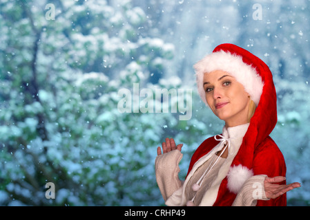 Frau trägt Weihnachtsmütze, winterliche Szene im Hintergrund, Porträt Stockfoto