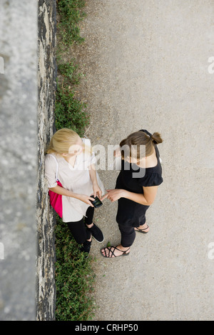 Junge Frauen Blick auf Handy-gemeinsam im Freien, Overhead anzeigen Stockfoto
