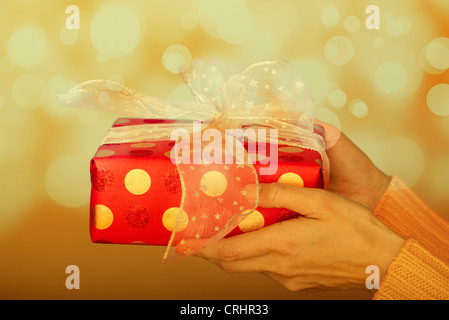 Frauenhand holding festlich verpackt Weihnachtsgeschenk Stockfoto