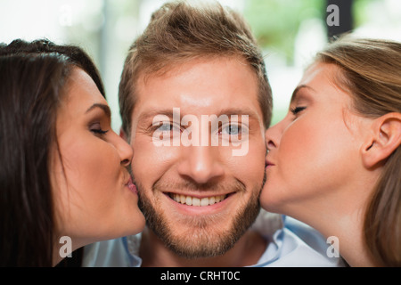 Frauen küssen Lächeln mans Wangen Stockfoto