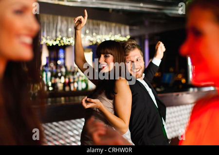 Lächelnd Freunde tanzen in Bar Stockfoto