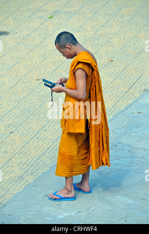 Munk mit zwei Moblie Telefonen in der Strees von Phnom Penh, Kambodscha Stockfoto