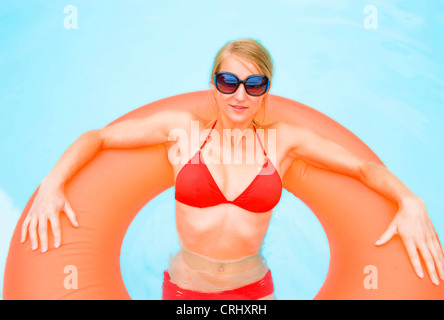 Junge, attraktive Frau in einem schwimmenden Reifen in einem Schwimmbad Stockfoto