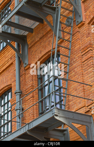 Stahl-Notausgang Leiter auf renovierten Fabrikgebäude mit Ziegelmauer Stockfoto