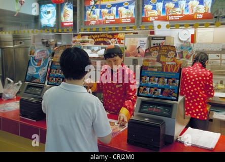 Mitarbeiter und Kunden in einem McDonalds Filiale in Singapur Stockfoto