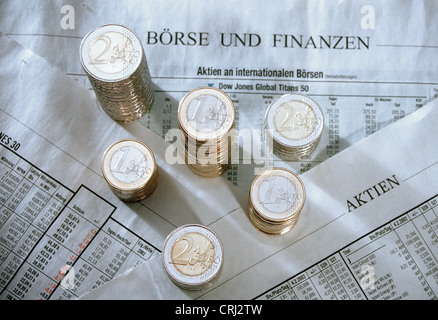 Stapel von Euromuenzen auf einer Zeitungsseite mit Börsenentwicklungen Stockfoto