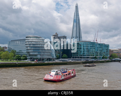 Der Shard, City Hall und More London am Ufer der Themse mit einem Boot von Touristen im Vordergrund Stockfoto