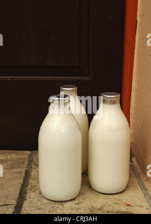 Flaschen Milch vor einer Haustür Stockfoto