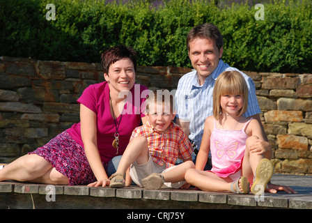 junge Familie mit zwei Kindern sitzen auf Promenade Stockfoto