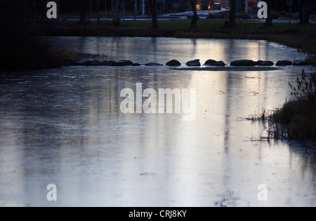 Erste Eisschicht auf einem Gartenteich, Finnland Stockfoto