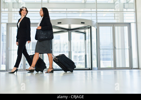 Geschäftsfrauen Rollgepäck in lobby Stockfoto