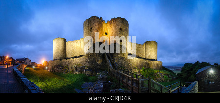 Panorama-Aufnahme von Harlech Castle an der Snowdonia-Küste des nordwestlichen Wales. Gelegen in Harlech, Gwynedd, Wales, wurde es von König Edward i. erbaut am Ende des 13. Jahrhunderts als Teil einer Reihe von Burgen im Nordwesten Wales. Auf diesem Foto, genommen in der Abenddämmerung lauern Omininous Regenwolken über Kopf. Der Aussichtspunkt ist das Haupttor-Haus, Blick nach Westen in Richtung der irischen See (die Küste in der Ferne auf der rechten Seite des Rahmens zu sehen). Stockfoto