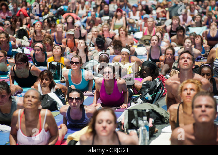 Tausende von Yoga-Praktizierende auf dem Times Square in New York teilnehmen an einen Mittag Bikram Yoga-Kurs Stockfoto