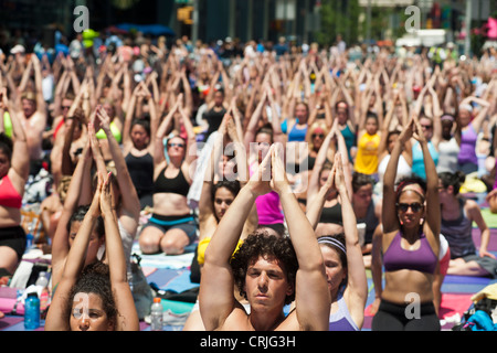 Tausende von Yoga-Praktizierende auf dem Times Square in New York teilnehmen an einen Mittag Bikram Yoga-Kurs Stockfoto
