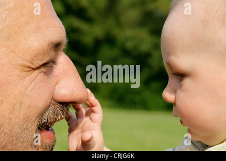 Baby-grabbing für Großvaters Nase, Deutschland Stockfoto