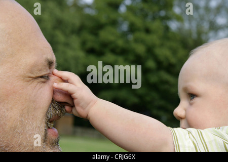 Baby-grabbing für Großvaters Nase, Deutschland Stockfoto