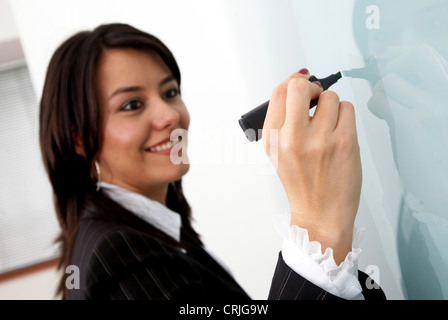 Business-Frau etwas auf eine Wand im Büro schreiben Stockfoto