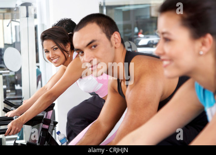 Menschen in der Turnhalle der Ausarbeitung auf den Radsport Maschinen Stockfoto