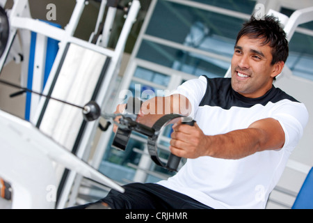 Mann in der Turnhalle Übung auf einem Rechner mit Gewicht Stockfoto