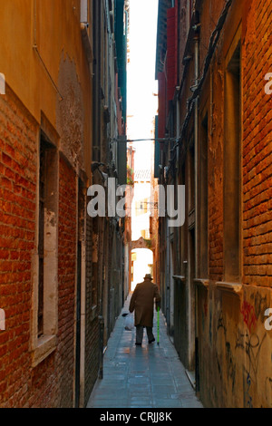 Alter Mann zu Fuß durch eine schmale Gasse in Venedig, Italien, Venedig Stockfoto