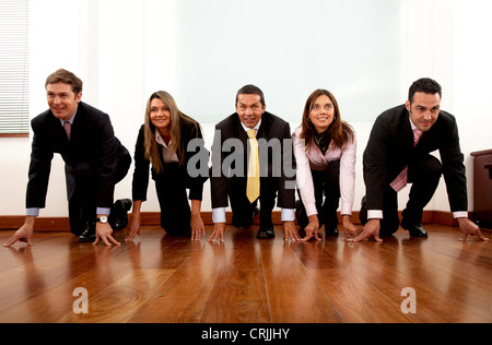 5 junge Geschäftsleute in Folge in die Ausgangsposition für ein Rennen Stockfoto