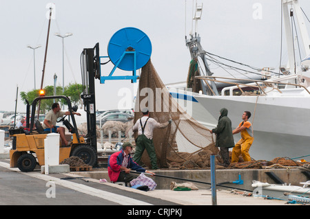 Fischern, Reparatur und entwirrt ein Fischernetz im Hafen, Frankreich, Languedoc-Roussillon, Camargue, Le Grau-du-Roi Stockfoto