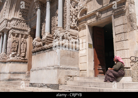 Zigeunerin sitzen und betteln vor der Kirche St. Trophime, Frankreich, Provence, Camargue, Arles Stockfoto