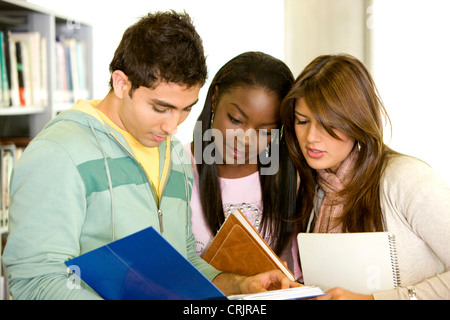 Freunde oder Studenten lächelnd in einer Bibliothek Stockfoto