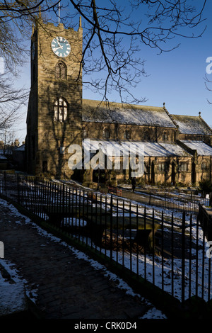 Pfarrkirche St. Michael & All Angels und Haworth Kirchhof im Winter mit einer Bedeckung von Schnee. Stockfoto