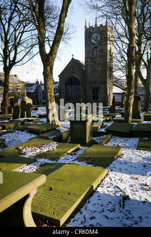 Pfarrkirche St. Michael & All Angels und Haworth Kirchhof im Winter mit einer Bedeckung von Schnee. Stockfoto