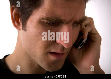 Ein besorgt junger Mann telefonieren mit einem Handy. Stockfoto