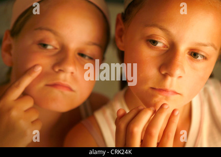 Zwei Mädchen überprüfen ihre Gesichter für Flecken. Stockfoto