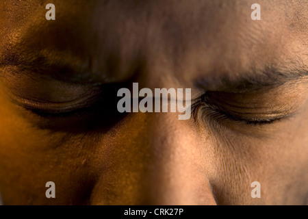 Ein junger Mann drückt seine Augen geschlossen. Stockfoto