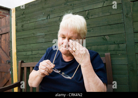 ältere Dame in ihrem Garten zu weinen Stockfoto