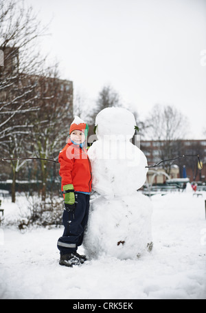 Junge Gebäude Schneemann im park Stockfoto