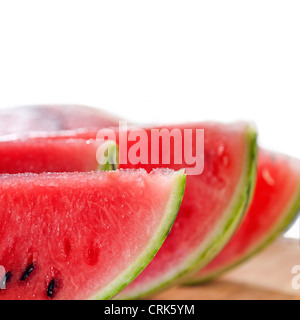 frische reife Wassermelone in Scheiben geschnitten auf einem Holztisch auf weißem Hintergrund Stockfoto