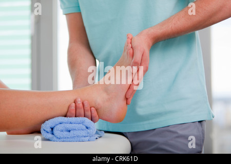 Arzt untersucht Womans Füße im Büro Stockfoto