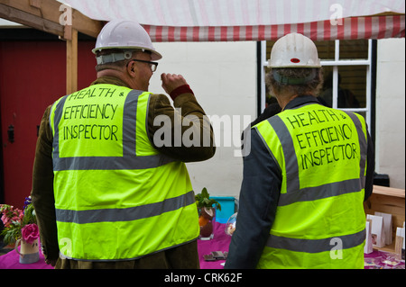 Komödie-Gesundheit und Effizienz Inspektoren an Ständen während Presteigne Essen Trail Festival bei Presteigne Powys Mid-Wales UK suchen Stockfoto