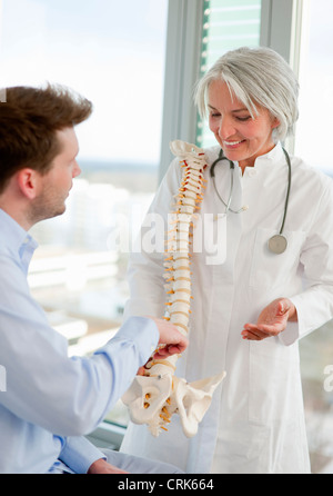 Arzt zeigt Wirbelsäule Modell für Patienten Stockfoto