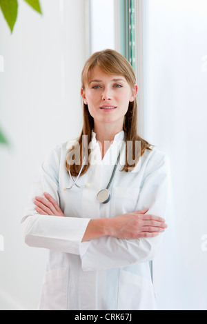 Arzt steht mit verschränkten Armen Stockfoto